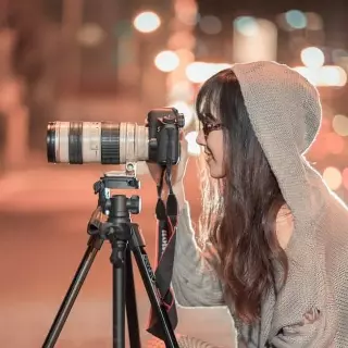 Jeune femme prenant une photo avec un appareil photo professionnel