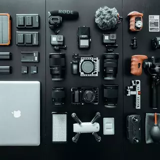 photographie représantant du matériel informatique avec drone, appareils photo, micros, batteries, ordinateurs portables.